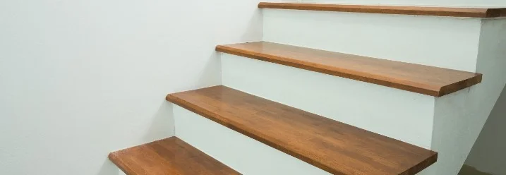 Holztreppe mit weißer Wand